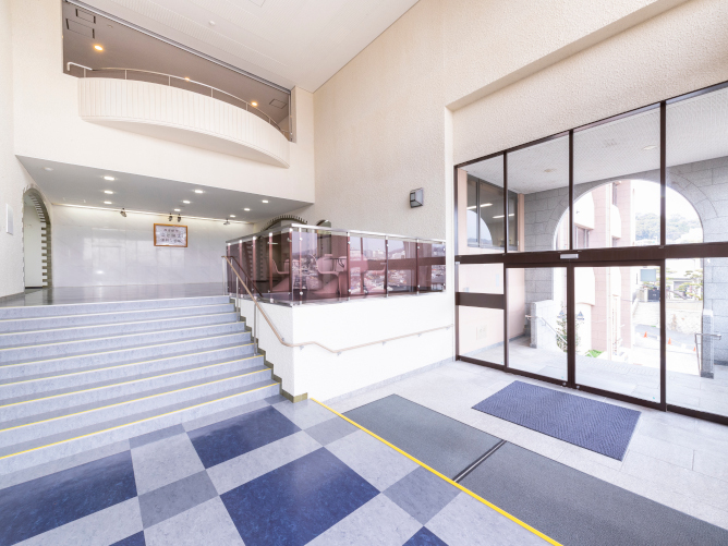 階段を上がると大きな窓と開放的な空間のエントランス