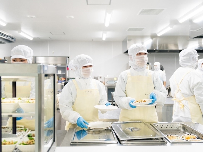 給食経営管理実習室：各種調理機器や下処理室や食器洗浄室を完備し、大量調理に関する知識や実践的な手法を学びます。