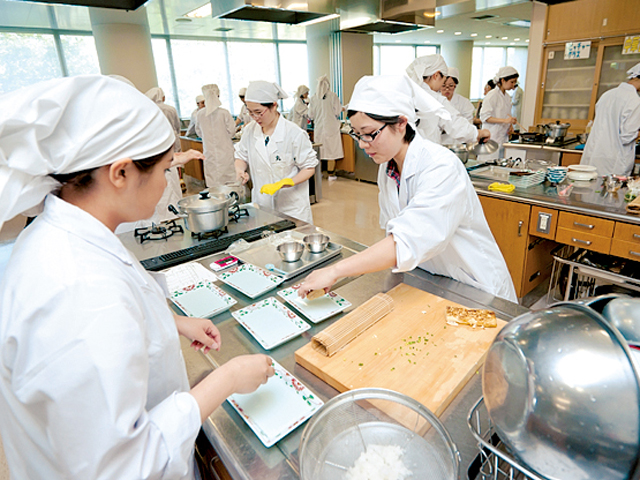 調理学実習室は、講義室と試食室を併設。講義室には左右に2台のディスプレイを設置し、学生たちが調理中の講師の手元を大きな画面で確認できるよう工夫されています。